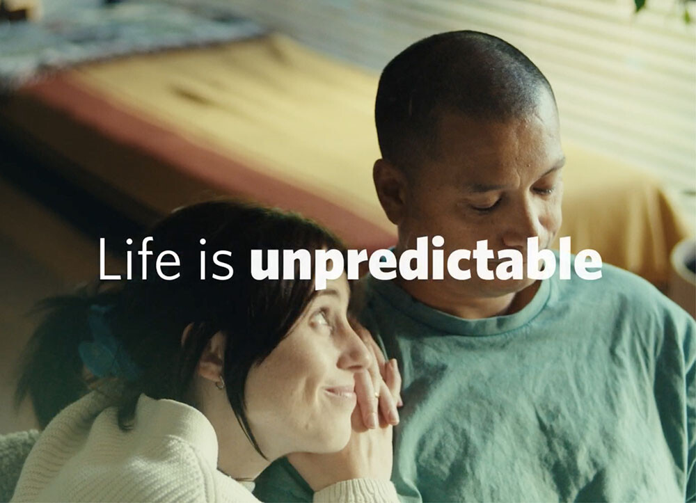 A couple sitting on a couch, with the words "life is unpredictable" written across the image.